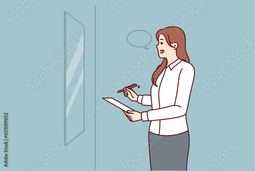 Woman is rehearsing motivational speech standing in front of mirror and learning oratory and persuasive skills. Businesswoman with pen and piece of paper rehearsing presentation speech for conference