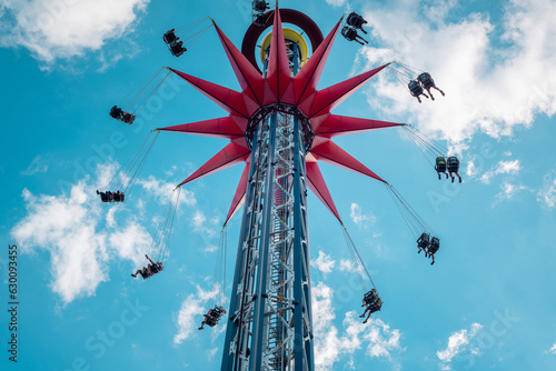 Photo A spinning extreme attraction against the blue sky in the amusement park of the city of St
