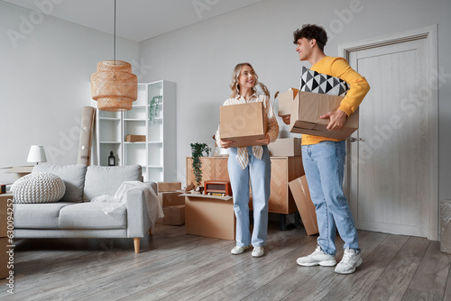 Young couple with cardboard boxes in room on moving day