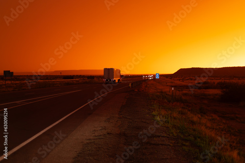 Freight delivery truck transporting cargo on interstate freeway at stunning sunset 