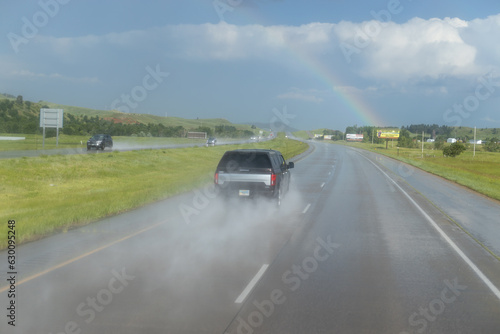 a car drives at high speed on the wet road. a rainy day by projecting a water splash