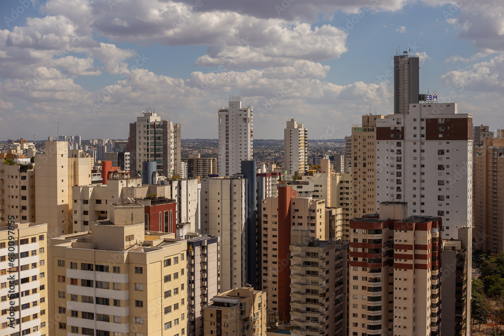 Vista panorâmica da cidade de Goiânia com vários prédios em um dia claro com algumas nuvens no céu.