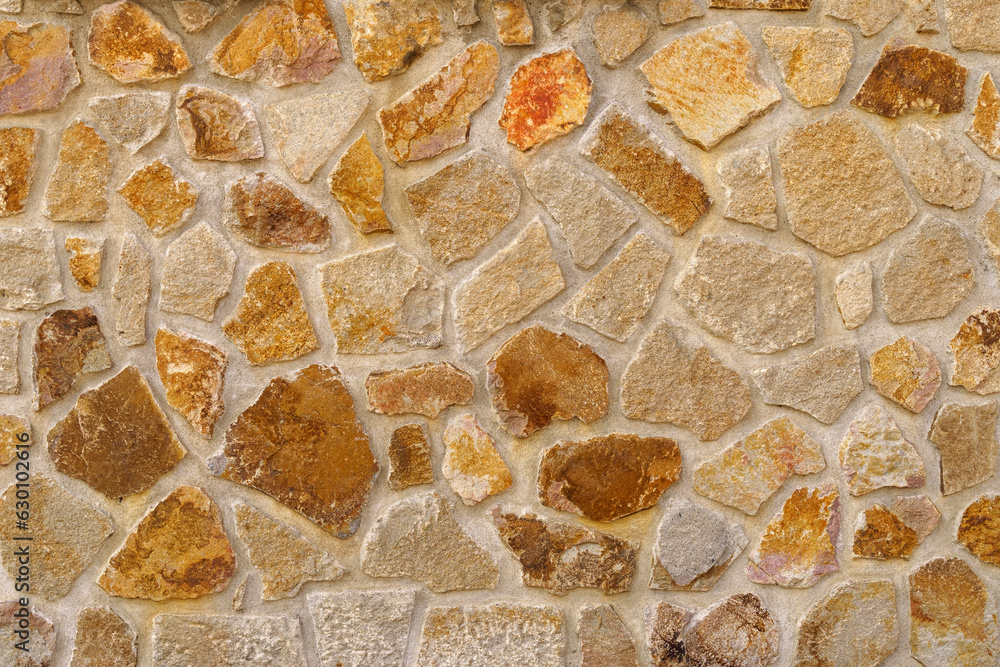 The texture of the old medieval wall of the house, lined with brown stone The texture of the old medieval wall of the house, lined with brown stone