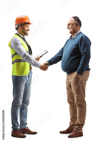 Full length profile shot of a an engineer shaking hand with a mature man