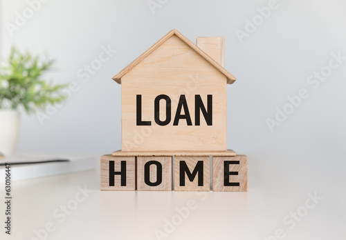 Home loan concept. A small wooden house with wooden block and text on white background.