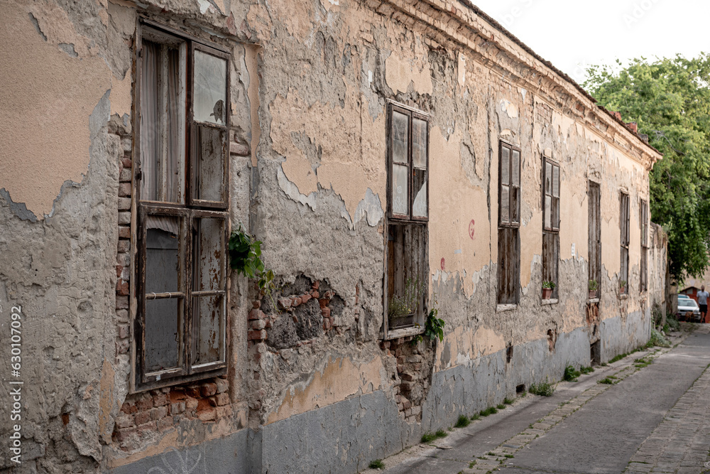 Exterior of aged abandoned building with crumbling stone walls and small windows Exterior of aged abandoned building with crumbling stone walls and small windows