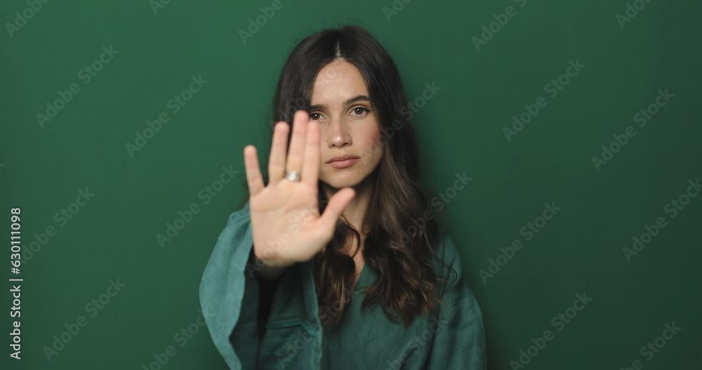 Brunette woman making hands stop action sign. I said, no. Angry frustrated young woman showing crossed arms in x gesture sign and looks on camera. Forbidden gesture standing isolated green background. Brunette woman making hands stop action sign. I said, no. Angry frustrated young woman showing crossed arms in x gesture sign and looks on camera. Forbidden gesture standing isolated green background.