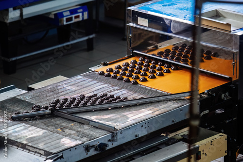 Process of chocolate glazing marshmallows in confectionery on conveyor machine, close up