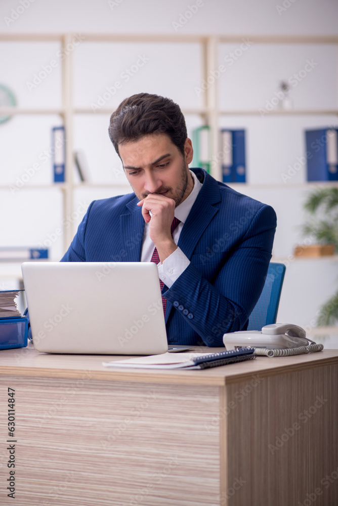 Young male employee and too much work in the office Young male employee and too much work in the office