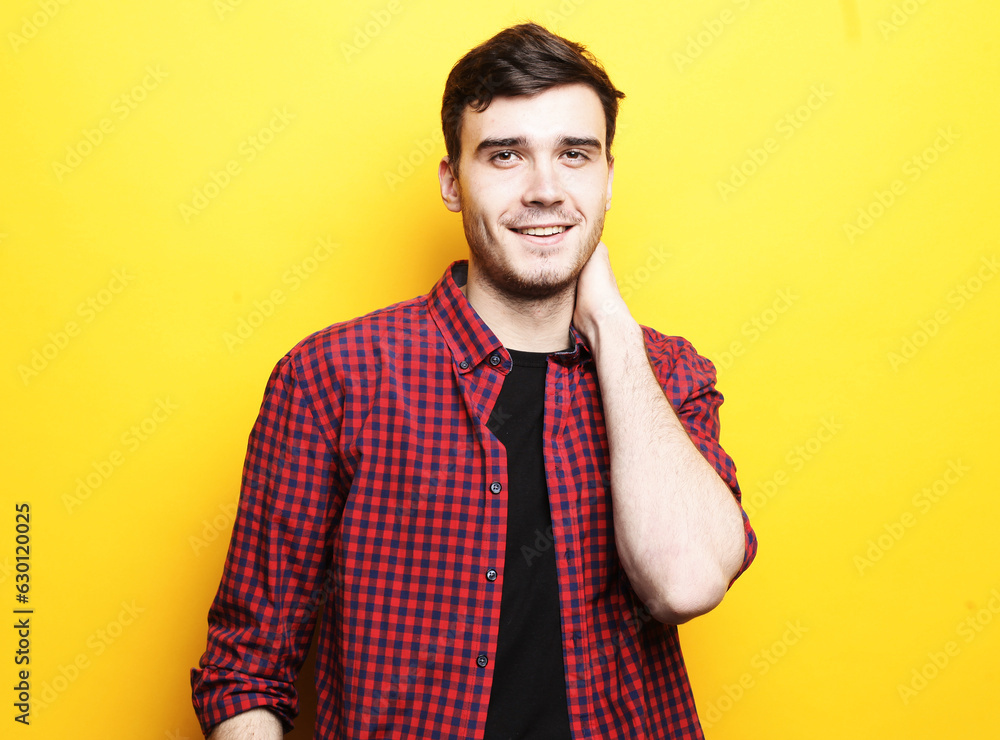 Smiling handsome male model in casual shirt on a yellow background. Smiling handsome male model in casual shirt on a yellow background.