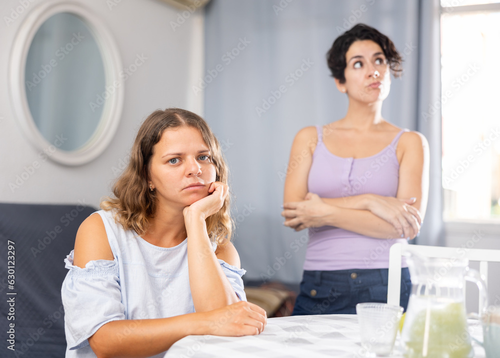 Stressed young LGBTQ female couple feeling offended after quarrel at home