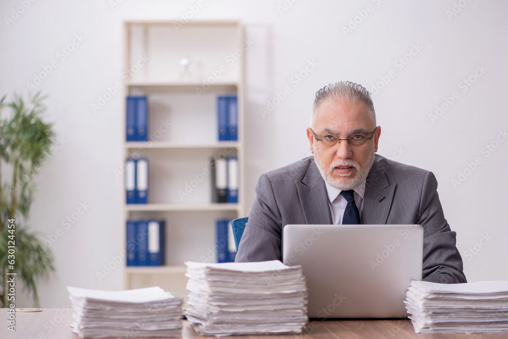 Old male employee and too much work at workplace Old male employee and too much work at workplace