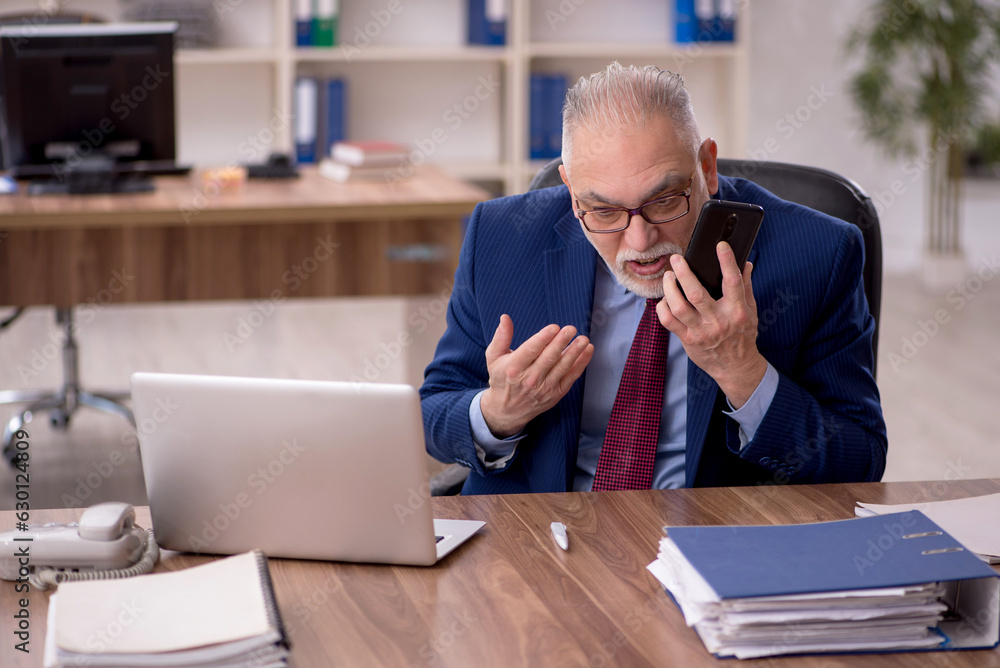 Old male employee working in the office Old male employee working in the office