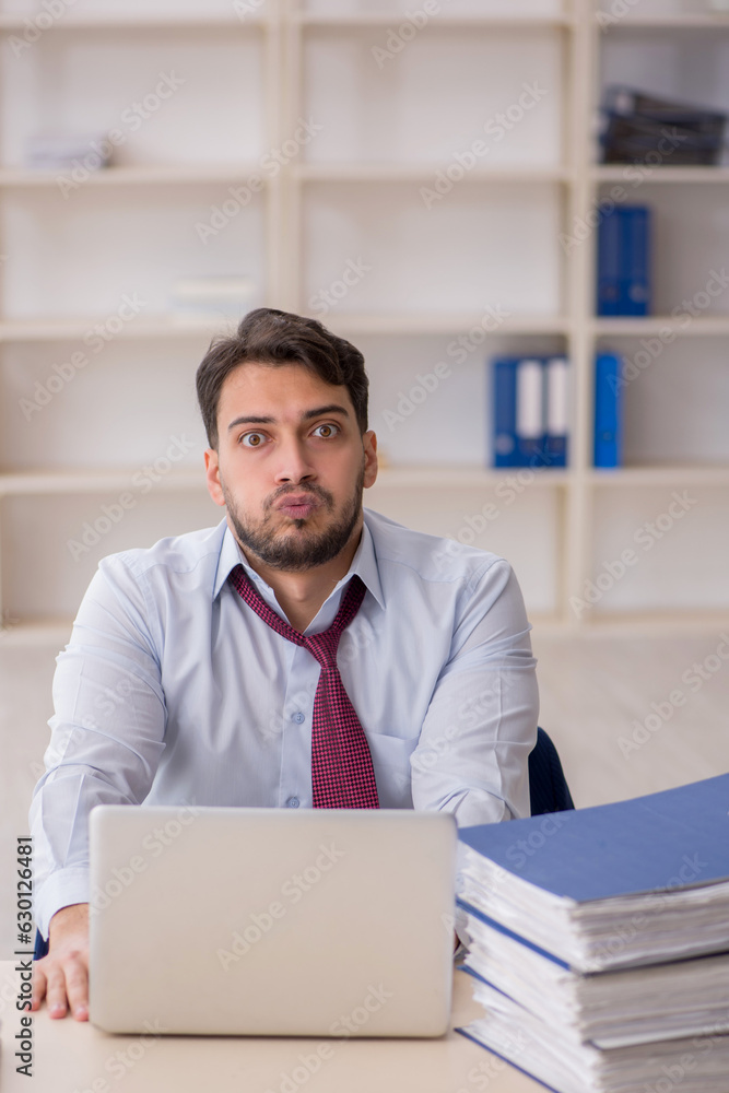 Young male employee sitting at workplace Young male employee sitting at workplace