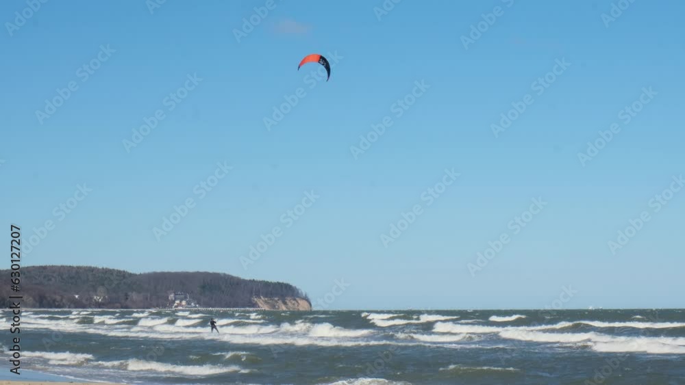 Wing Foiling kitesurfing wind surfing water outdoor sport in Baltic sea Dark blue clouds ocean water surface with foam waves before storm, dramatic seascape background. 