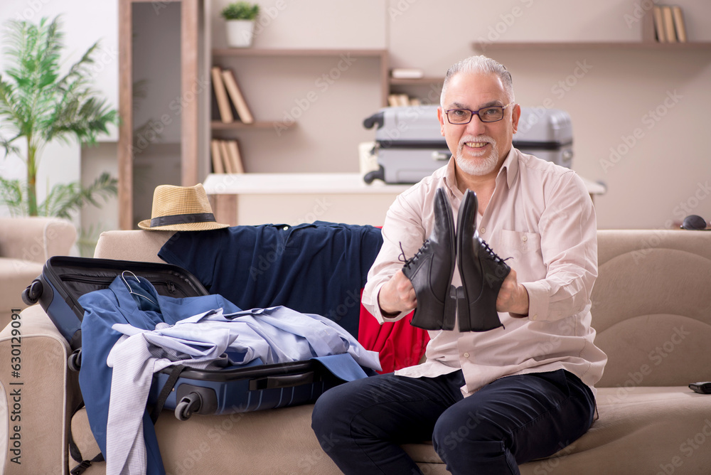 Fototapeta premium Old man preparing for trip at home
