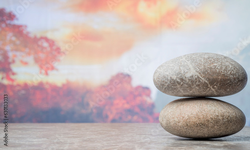 autumn podium with zen stones against autumn nature and sky for product presentation background