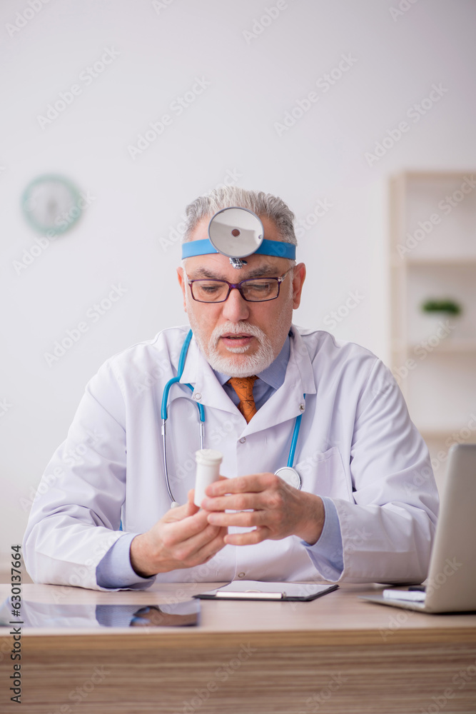 Old male doctor otologist working in the clinic