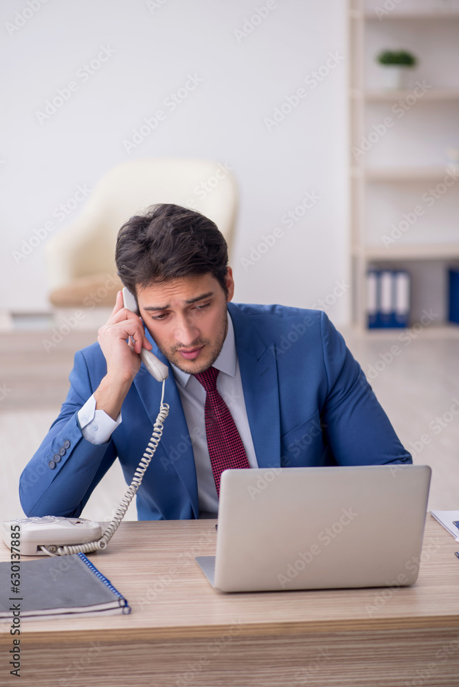 Young male employee working in the office Young male employee working in the office