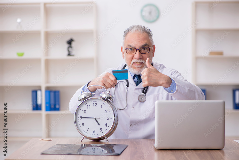 Old male doctor in time management concept Old male doctor in time management concept