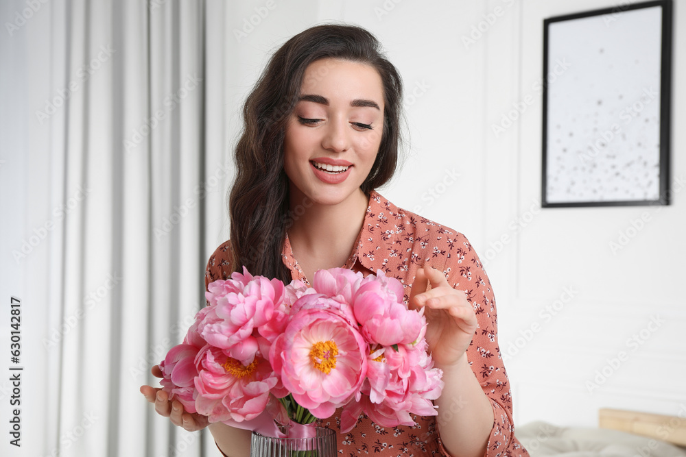 Beautiful young woman with bouquet of pink peonies at home Beautiful young woman with bouquet of pink peonies at home
