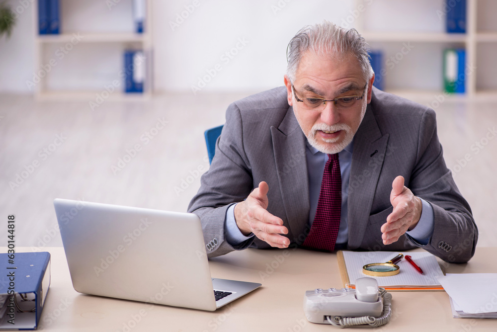 Old male employee working in the office Old male employee working in the office
