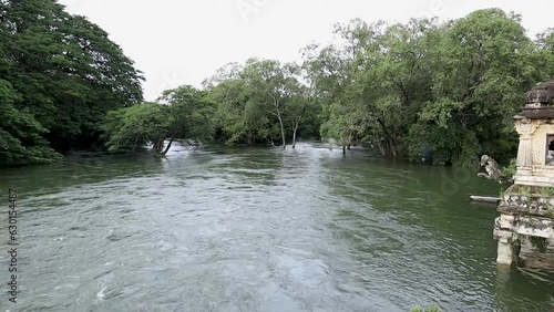 Mysuru,Karnataka,India-July 2022; A Pleasant view of a Picturesque location with trees and the majestically  overflowing river water during the Monsoon in Karnataka, India. photo