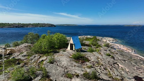 Aerial view away from a self-sufficient cabin on a rocky island, in sunny Finland photo