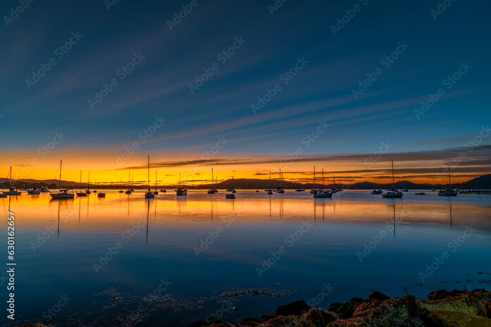 Beautiful sunrise with high cloud and boats on the water Beautiful sunrise with high cloud and boats on the water