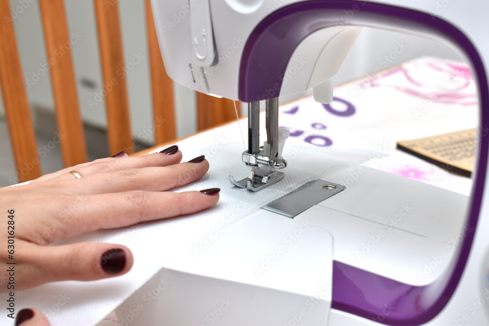 woman using a sewing machine sewing fabrics
