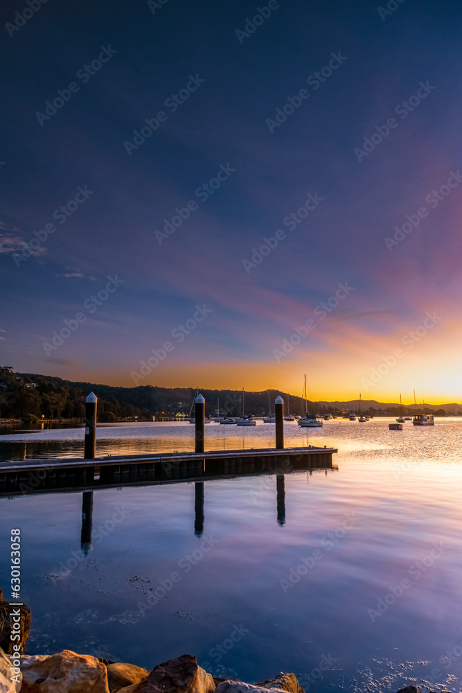 Beautiful sunrise with crepuscular rays and boats on the water