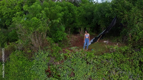 Asian Woman Standing Over The Cliff Edge Near Uluwatu In Bali, Indonesia. Aerial Drone Shot photo