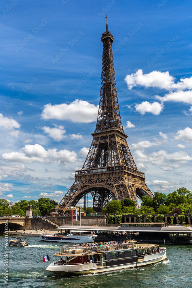 Fototapeta premium Eiffel tower and river cruise boat on Seine river in Paris, France