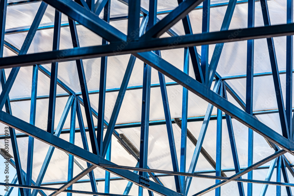 steel beams structure of transparent roof. industrial building or warehouse. closeup bottom view. steel beams structure of transparent roof. industrial building or warehouse. closeup bottom view.