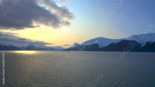 Drone rising up and showing the sun and mountains at sunrise along the Seward Highway. 4k drone. photo