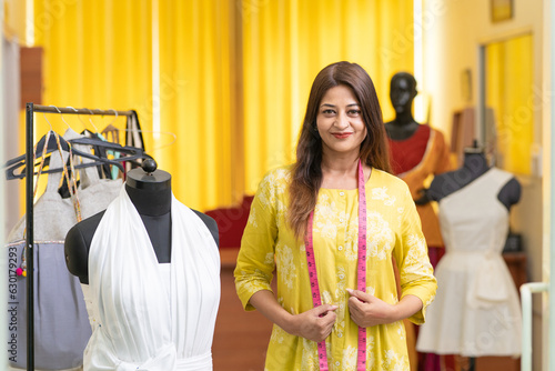 Young indian female fashion designer standing at store