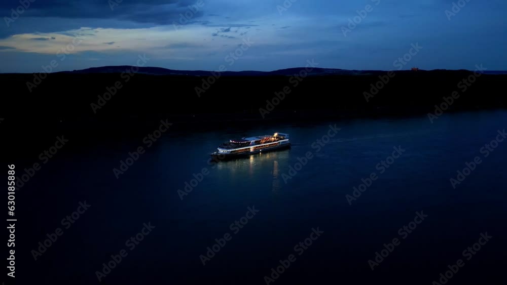 Aerial View Of Ship Cruising Danube River At Night - drone shot Aerial View Of Ship Cruising Danube River At Night - drone shot