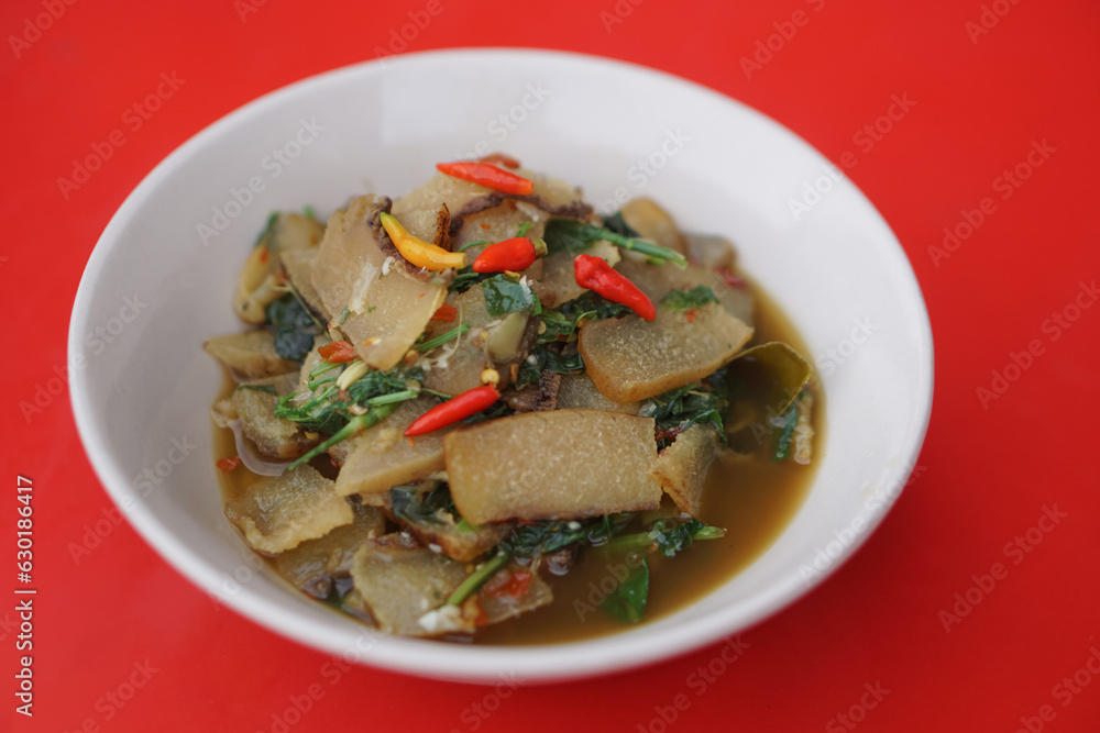 Beef skin curry, on white bowl, cook from dried fermented buffalo or cow skin as food preservation, curry with herbs Concept, Thai local food, traditional eating style. Beef skin curry, on white bowl, cook from dried fermented buffalo or cow skin as food preservation, curry with herbs Concept, Thai local food, traditional eating style.