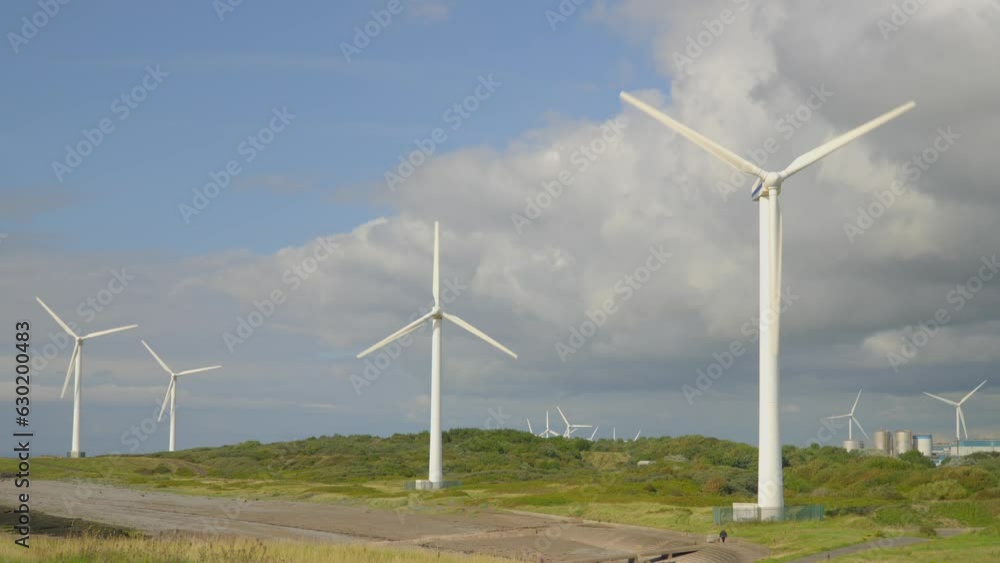 Many windmills turning at windy coastal location with storm clouds. Half speed slow motion. Many windmills turning at windy coastal location with storm clouds. Half speed slow motion.