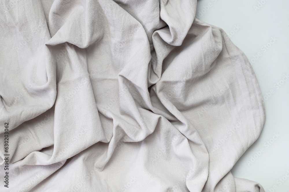 Fabric backdrop. Gray crumpled natural cotton fabric on light background. Natural linen background. Eco textiles. Gray Fabric texture. Top view flat lay with copy space 