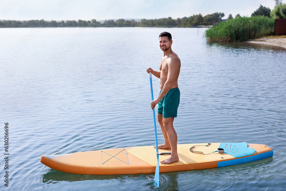 Man paddle boarding on SUP board in sea
