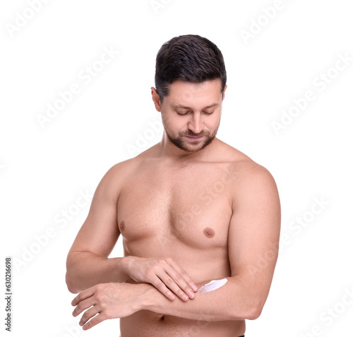 Handsome man applying sun protection cream onto arm against white background