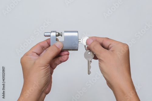 Close-up shot of hands holding metal padlock and keys