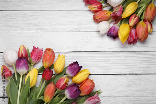 Fototapeta Naklejka Na Ścianę i Meble -  Beautiful colorful tulip flowers on white wooden table, flat lay. Space for text