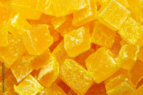 Diced mango dried fruits texture background, top view. Dehydrated mango chips dices, sweet food closeup