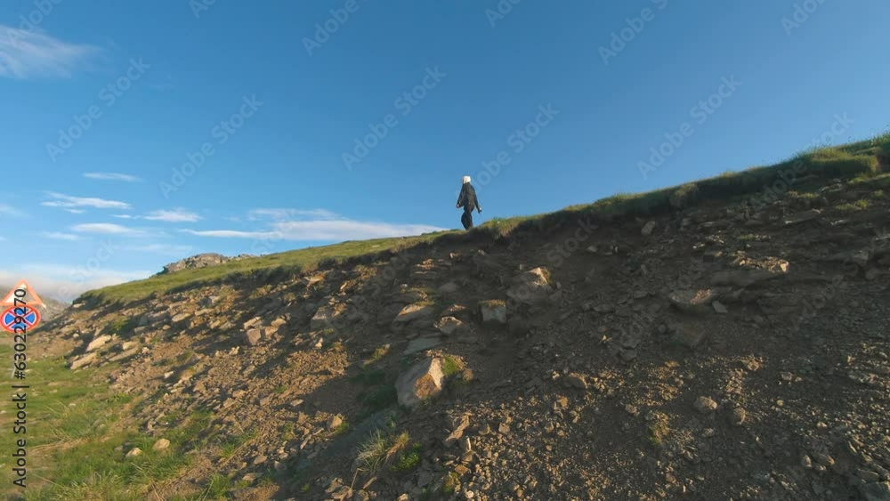 A beautiful Ukrainian young woman traveler walks along the most beautiful high mountain road in Romania Transalpina highway at sunset. Transalpina, Carpathian mountains in Romania at sunrise A beautiful Ukrainian young woman traveler walks along the most beautiful high mountain road in Romania Transalpina highway at sunset. Transalpina, Carpathian mountains in Romania at sunrise