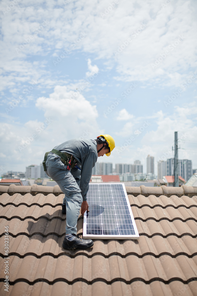 Builer installing solar panel on roof of client Builer installing solar panel on roof of client