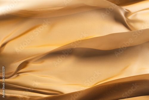 Close up of gold shiny silk fabric with copy space background photo