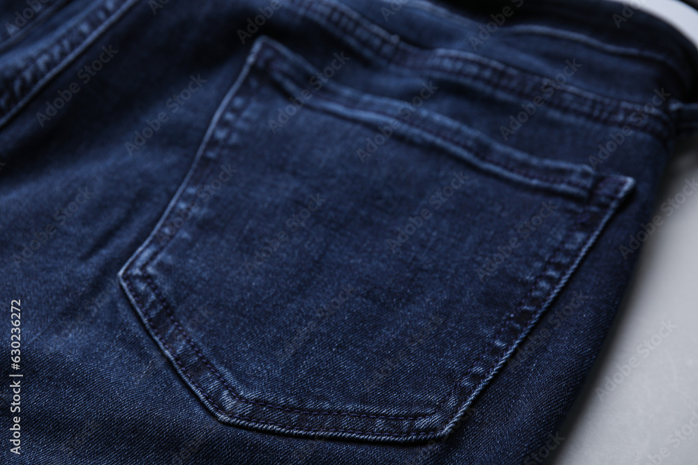 Jeans with pocket on grey background, closeup