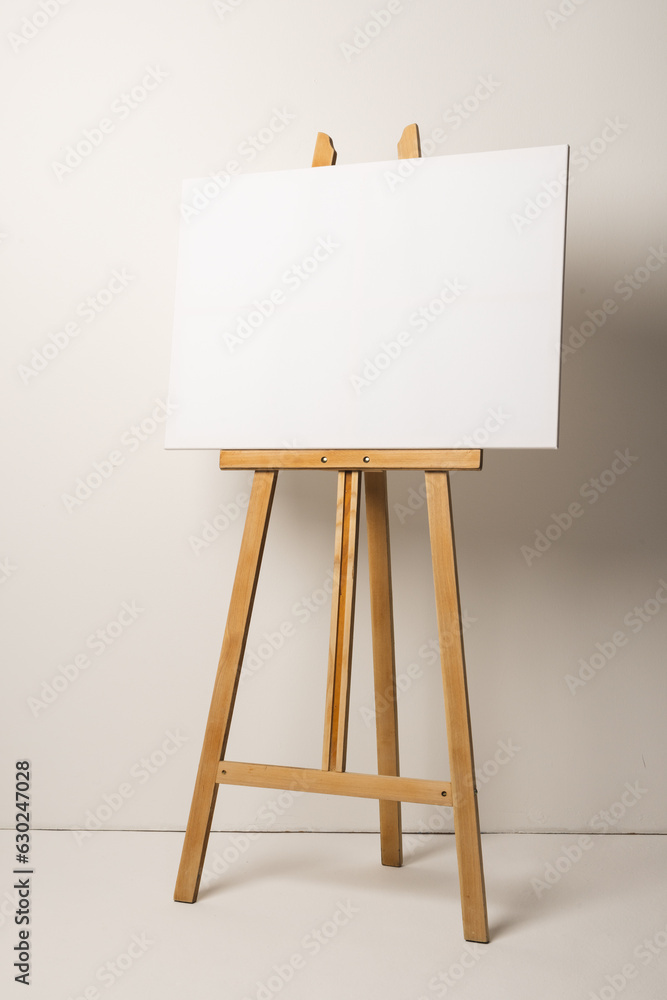 White canvas on wooden easel and copy space on white background White canvas on wooden easel and copy space on white background
